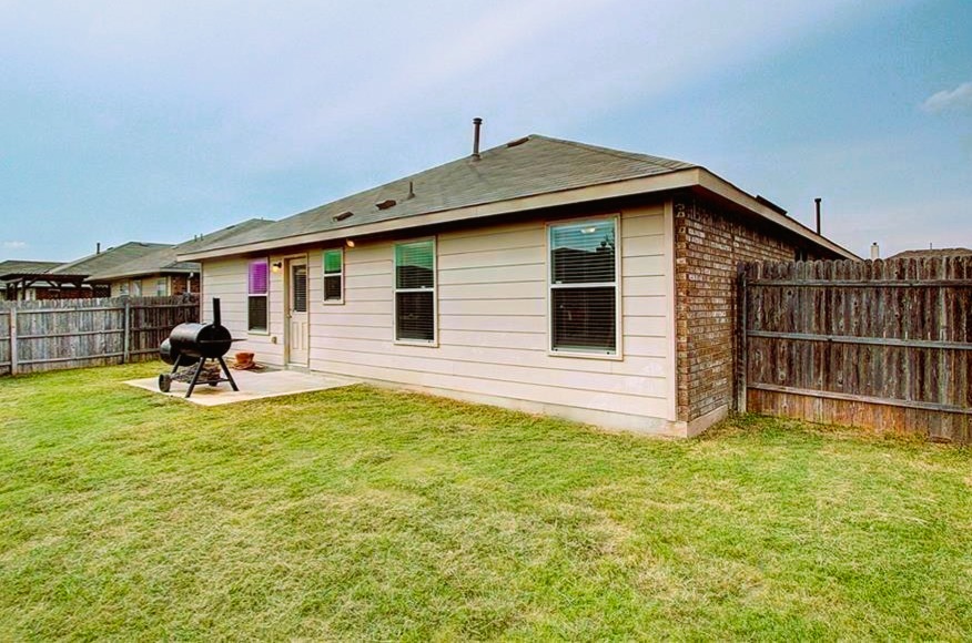 3609 Eagle Fledge Terrace Pflugerville, TX 78660 - Photo 5 of 15 Back of house with a patio area, a fenced backyard, and brick siding.