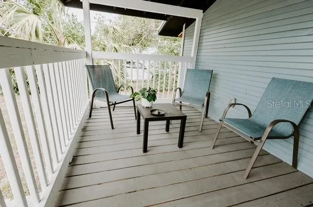 a view of a chairs and table in patio with wooden floor