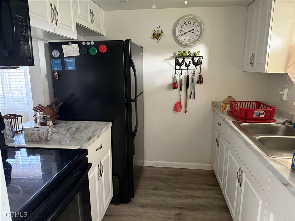 2211 Orchid Road Lehigh Acres, FL 33936 - Photo 5 of 11 a kitchen with a refrigerator and a sink