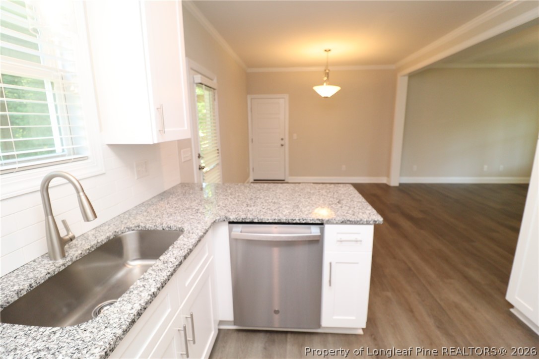 8424 Rhodes Road Apex, NC 27539 - Photo 15 of 31 a kitchen with granite countertop a sink a stove and cabinets