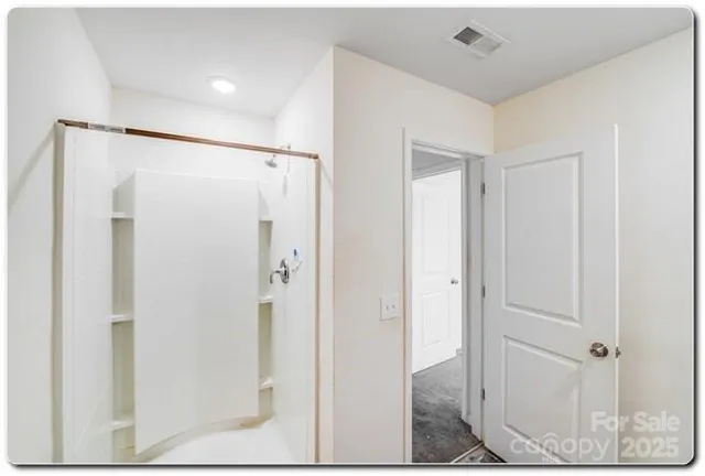 a bathroom with a shower and a glass door