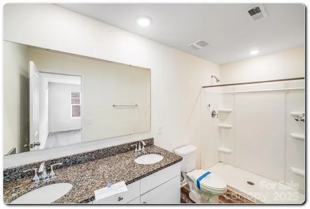 a bathroom with a granite countertop sink a mirror and shower