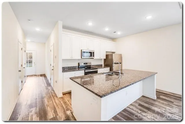 a kitchen with sink refrigerator and microwave