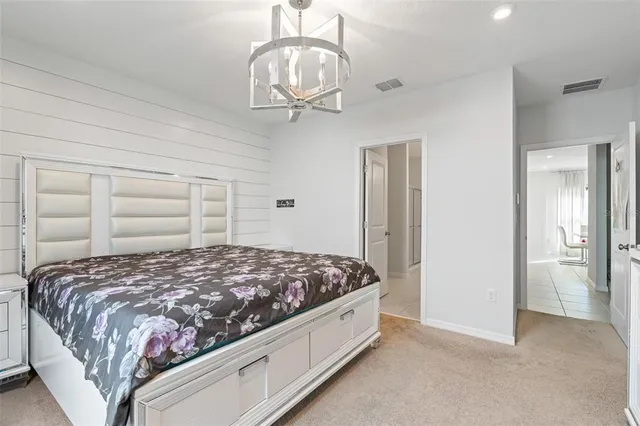 a bedroom with a bed and a chandelier
