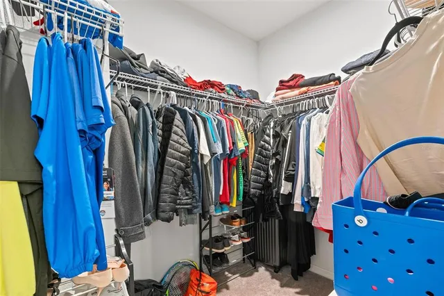 a view of walk in closet with clothes