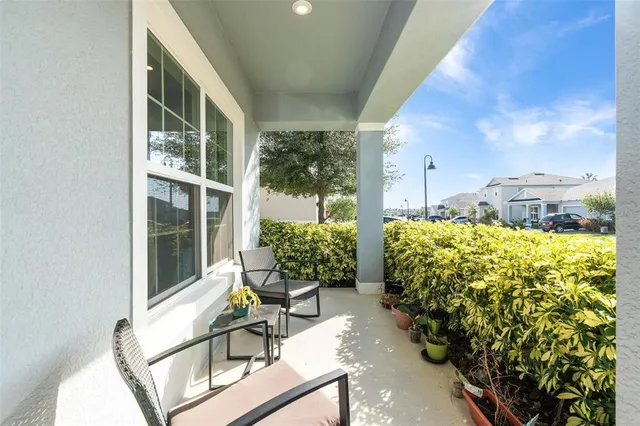 a balcony with chairs and potted plants