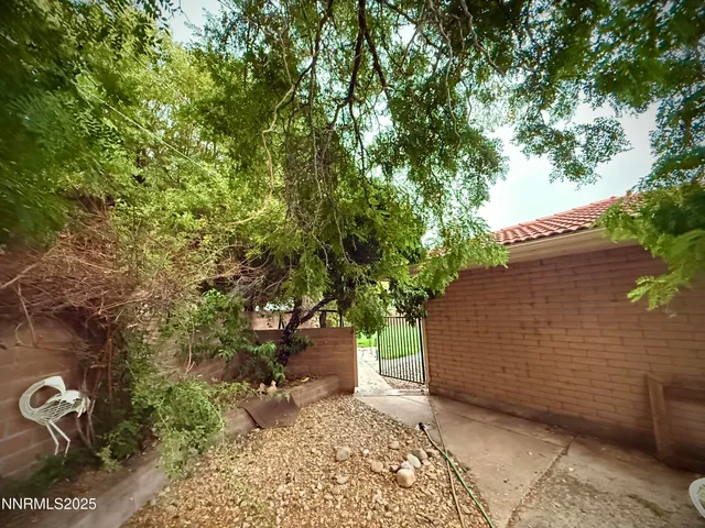 a view of a patio with table and chairs potted plants and large tree