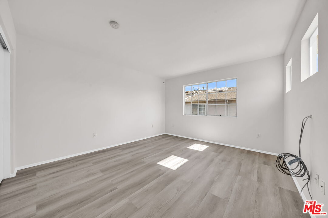 820 West Compton Boulevard, Unit 17 Compton, CA 90220 - Photo 20 of 50 an empty room with wooden floor cabinet and windows