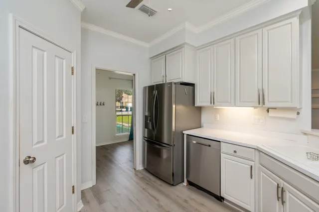 a kitchen with a refrigerator sink and cabinets
