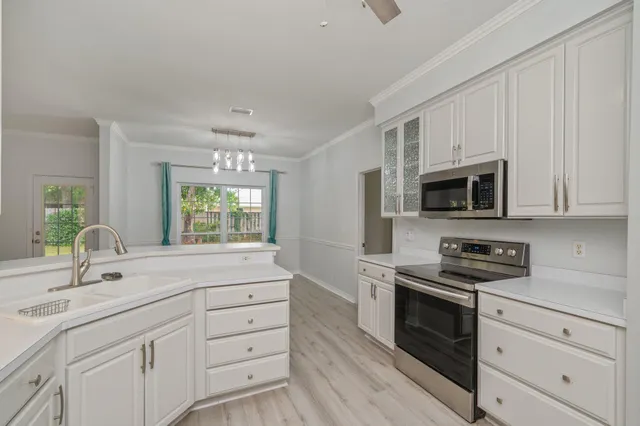 a kitchen with stainless steel appliances white cabinets and a sink