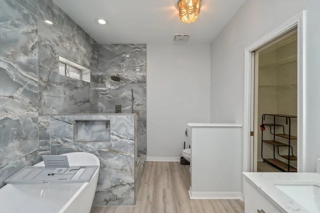 a bathroom with a sink a toilet and shower