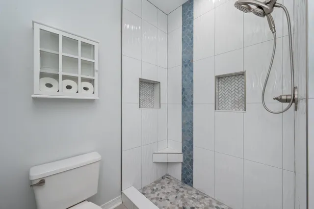 a bathroom with a toilet and a shower