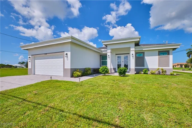 a view of a house with backyard and a garage