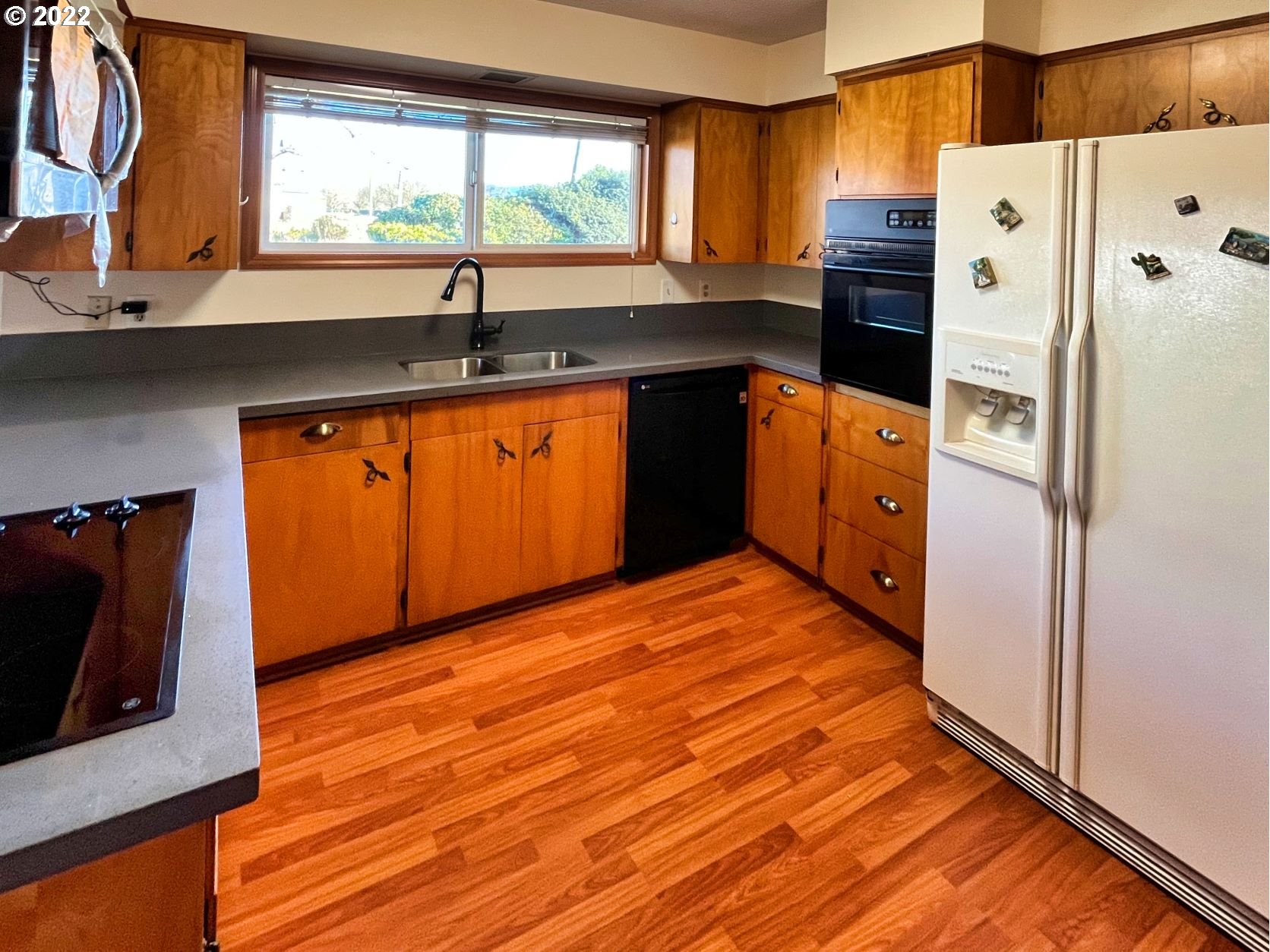 1675 Makinster Road Tillamook, OR 97141 - Photo 6 of 29 a kitchen with stainless steel appliances granite countertop a refrigerator a sink dishwasher a stove and a dining table with wooden floor