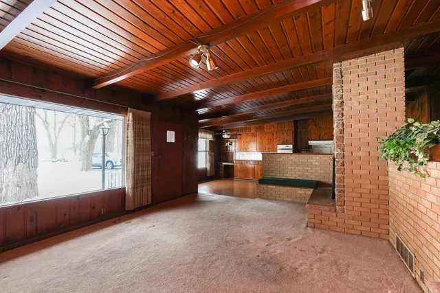 a view of an empty room with a fireplace and a window