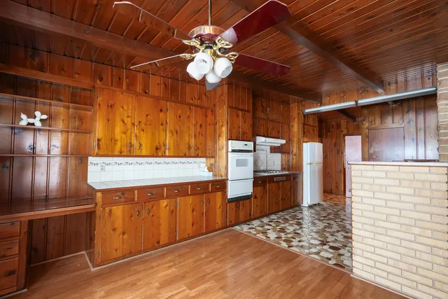 a kitchen with granite countertop a sink stove and cabinets