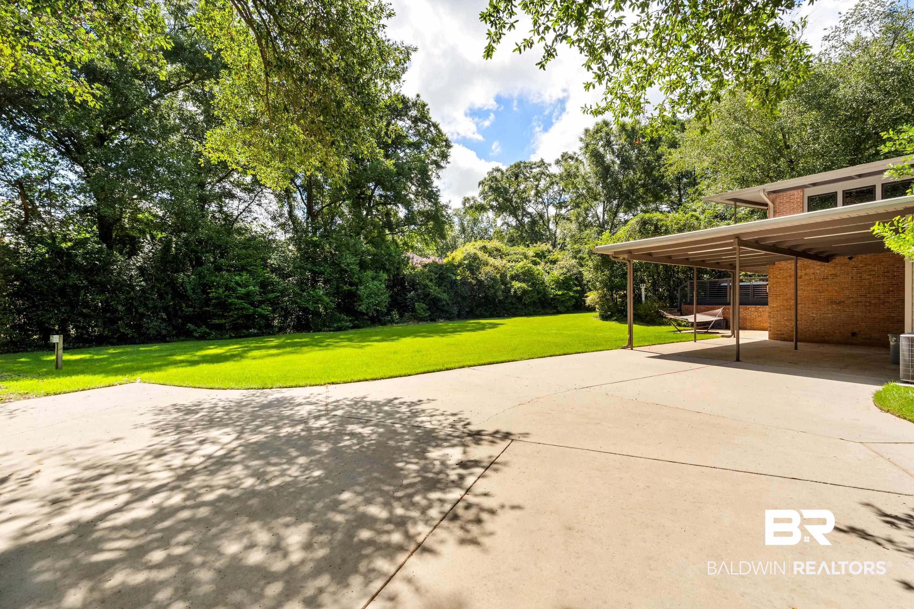 233 Suzanne Circle Mobile, AL 36608 - Photo 53 of 85 View of patio / terrace with driveway and view of wooded area