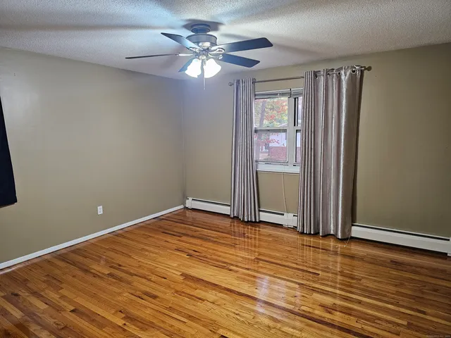 a view of an empty room with window chandelier fan