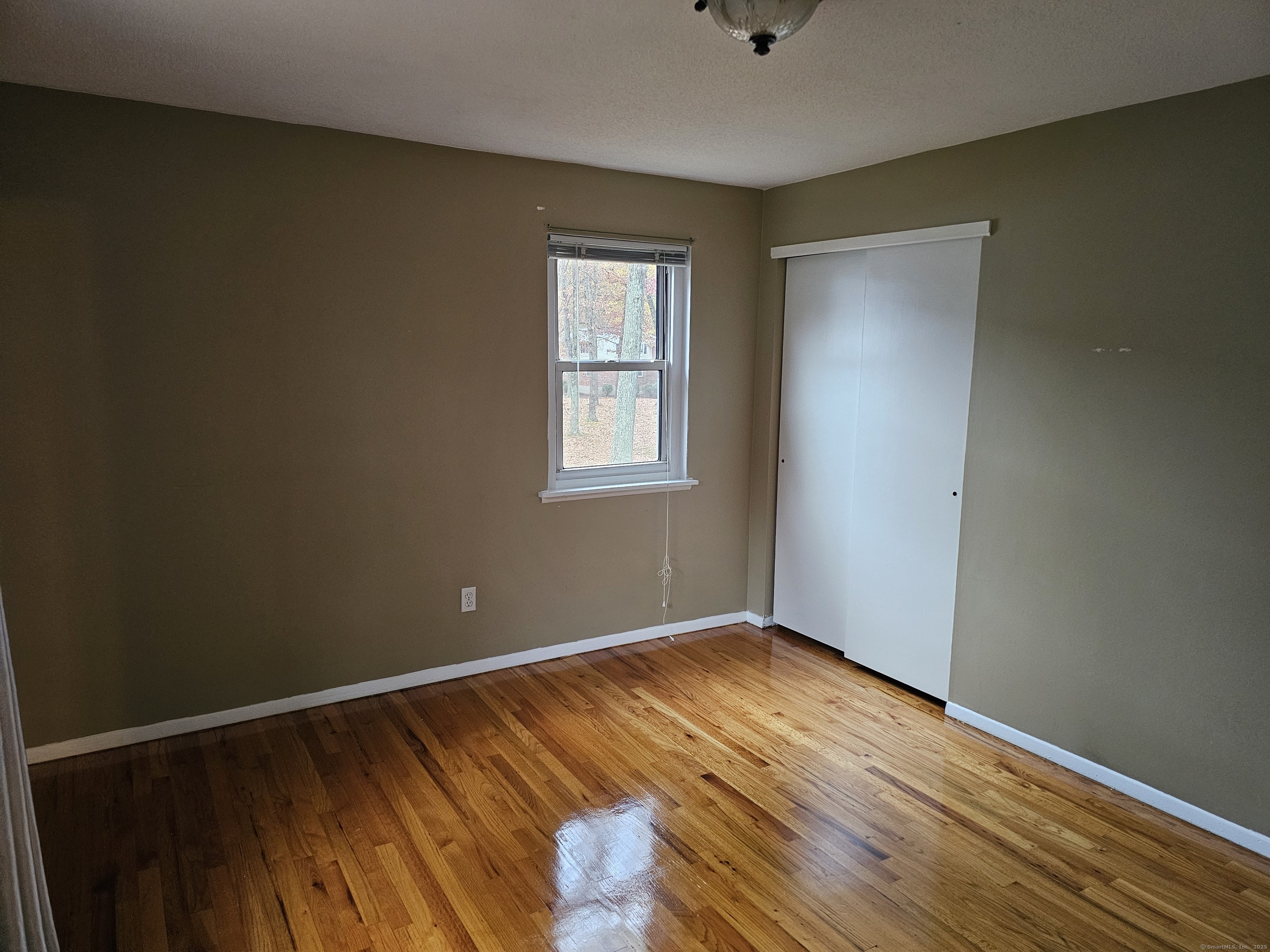 474 Oak Avenue, Unit 74 Cheshire, CT 06410 - Photo 6 of 10 a view of an empty room with wooden floor and a window