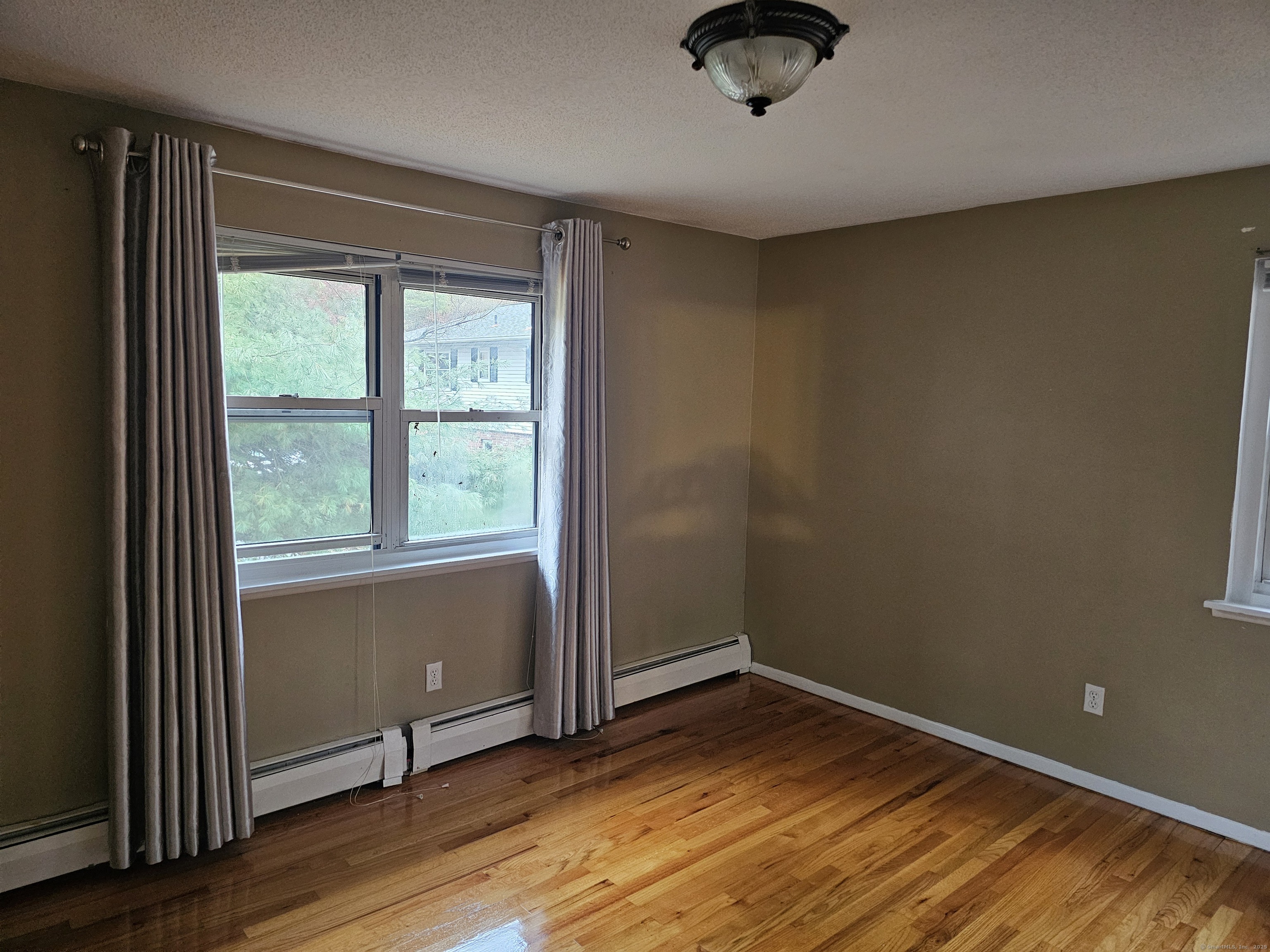 474 Oak Avenue, Unit 74 Cheshire, CT 06410 - Photo 7 of 10 an empty room with wooden floor and windows