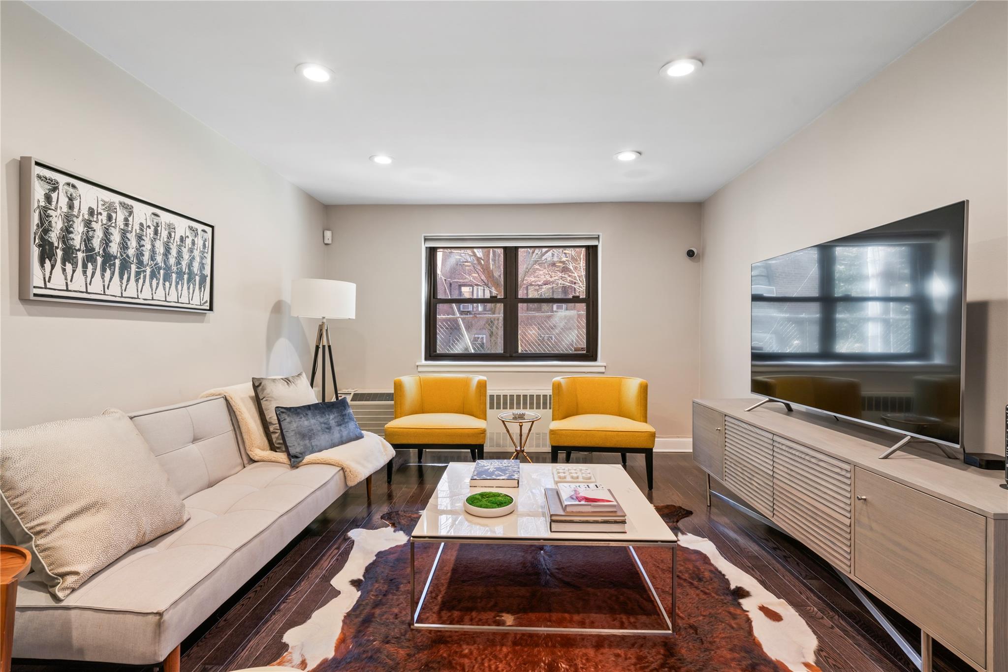 50 Brompton Road, Unit 1T Great Neck, NY 11021 - Photo 11 of 33 a living room with furniture a flat screen tv and a fireplace