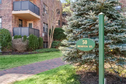 a sign board with a small yard and trees
