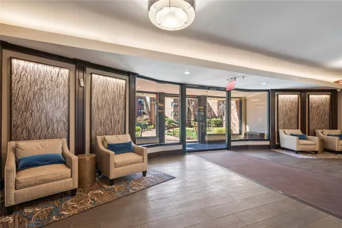 a living room with furniture and floor to ceiling window