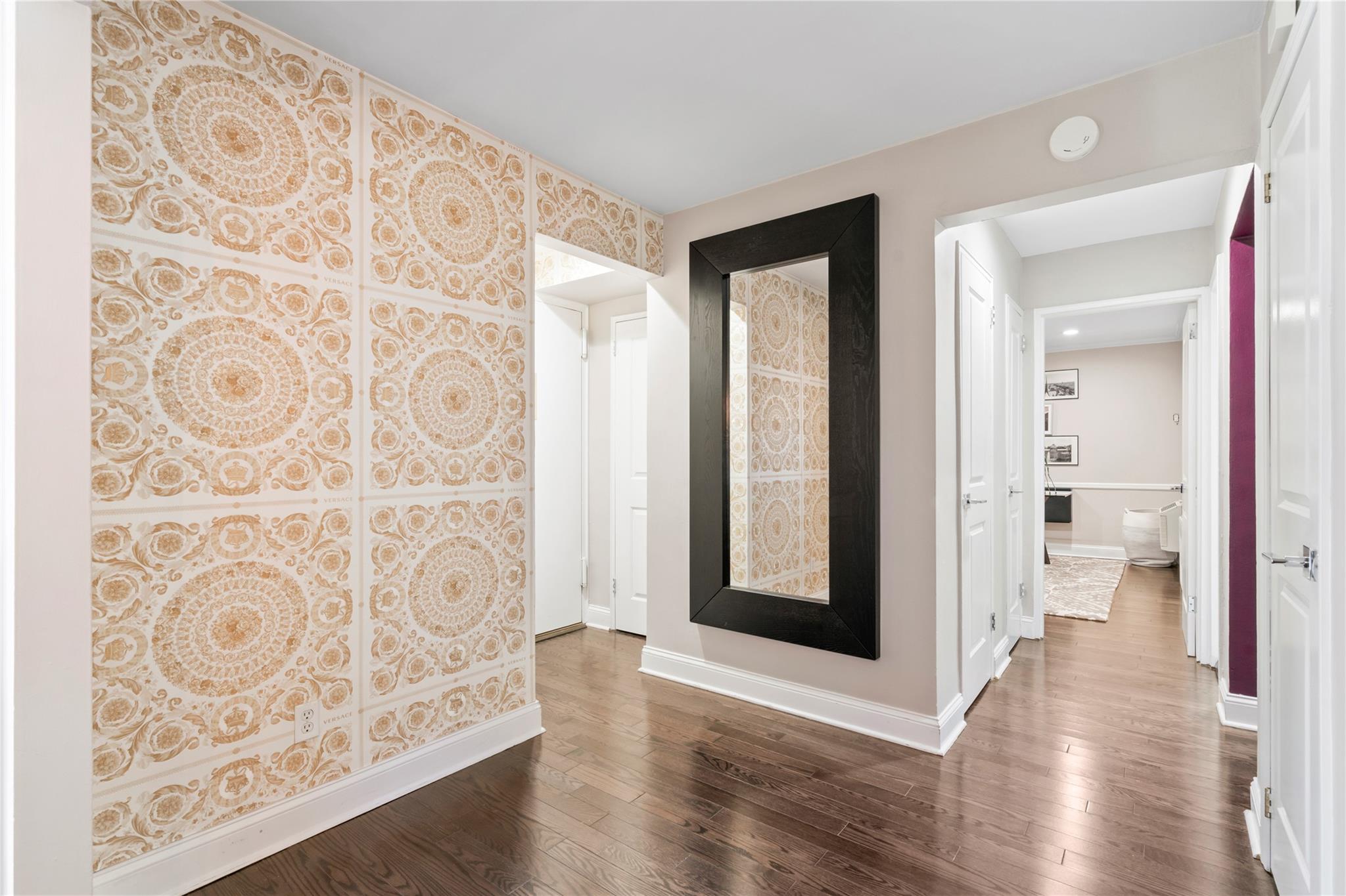 50 Brompton Road, Unit 1T Great Neck, NY 11021 - Photo 4 of 33 a view of a hallway with wooden floor and a living room