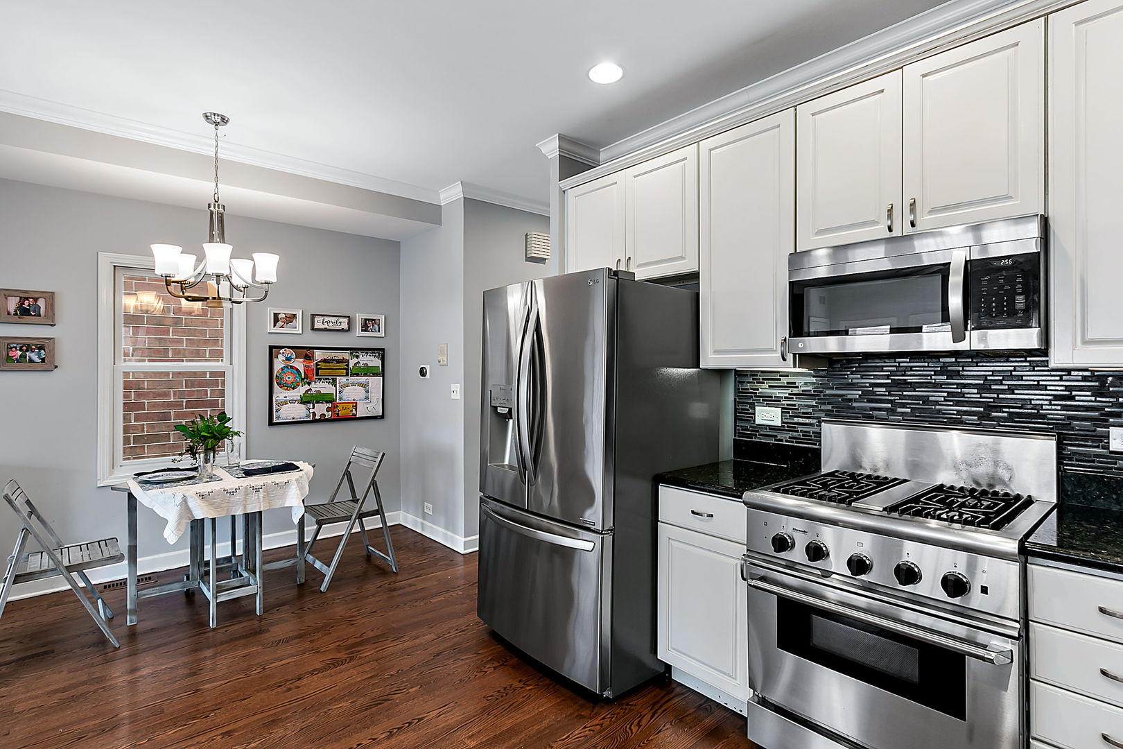 1910 West Barry Avenue Chicago, IL 60657 - Photo 11 of 33 a kitchen with stainless steel appliances a stove a sink dishwasher a refrigerator cabinets and a wooden floor