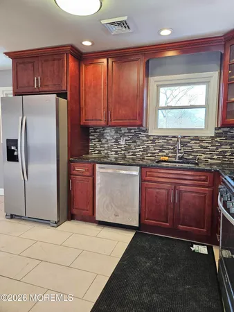 a kitchen with stainless steel appliances granite countertop a stove a sink dishwasher and a refrigerator