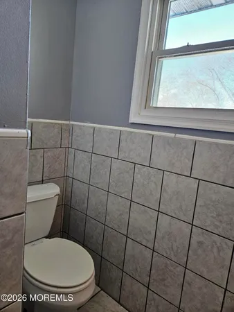 a white toilet sitting next to a window