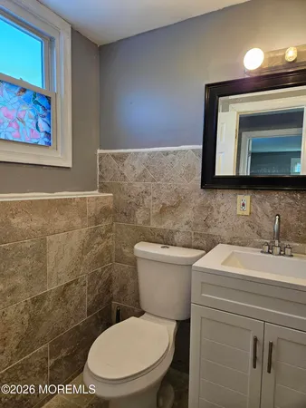 a bathroom with a toilet sink vanity and mirror