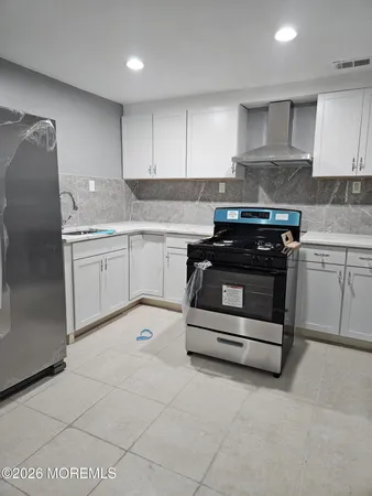 a kitchen with granite countertop a stove sink and cabinets