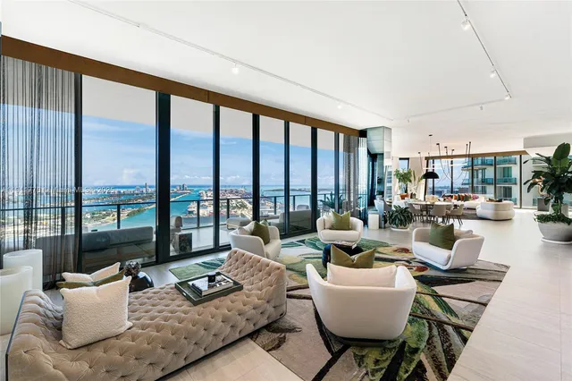 a living room with furniture and large windows