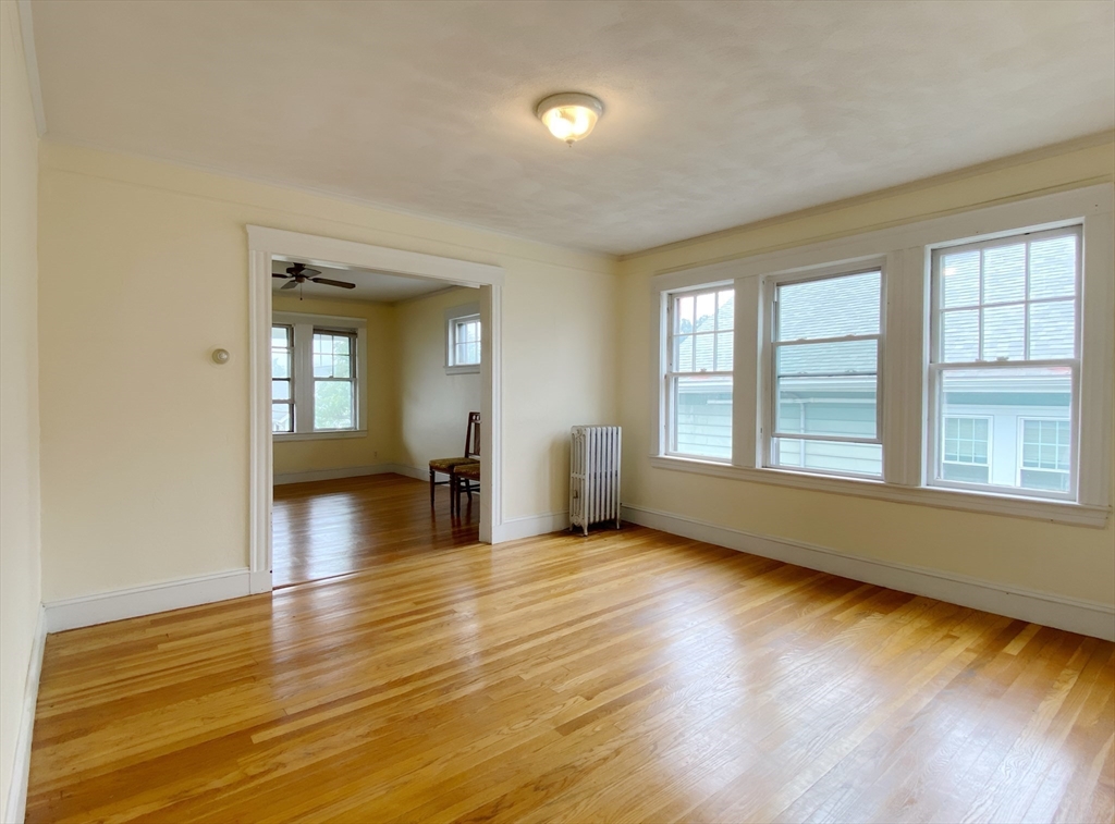 9 Cresthill Road, Unit 2 Somerville, MA 02145 - Photo 11 of 18 a view of an empty room with wooden floor and a window