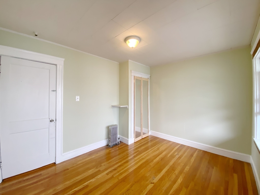 9 Cresthill Road, Unit 2 Somerville, MA 02145 - Photo 16 of 18 a view of empty room with wooden floor