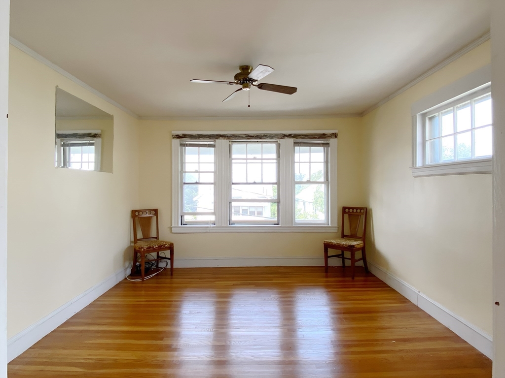 9 Cresthill Road, Unit 2 Somerville, MA 02145 - Photo 4 of 18 a view of an empty room with a window and wooden floor