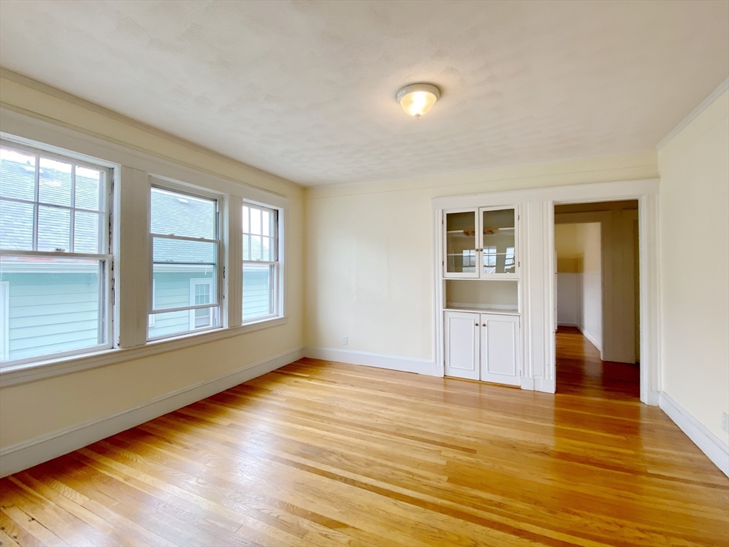9 Cresthill Road, Unit 2 Somerville, MA 02145 - Photo 6 of 18 a view of empty room with wooden floor and fan