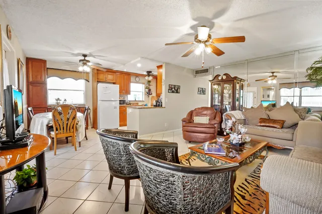 a living room with furniture a flat screen tv and a large window