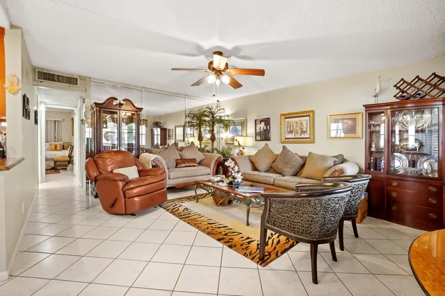 a living room with furniture a chandelier and a dining table
