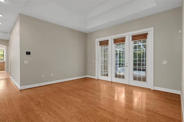 a view of an empty room with wooden floor and a bathroom