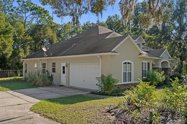 an aerial view of a house with yard and lake view