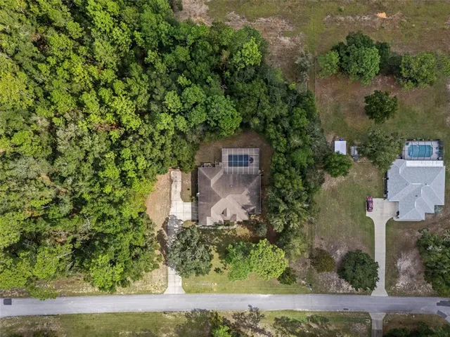 an aerial view of a house with a yard and lake view