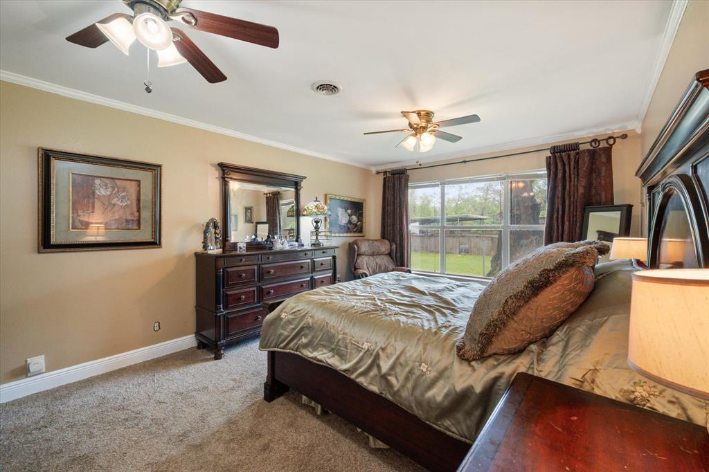 14036 Old Texaco Road Conroe, TX 77302 - Photo 11 of 40 Carpeted bedroom featuring baseboards, visible vents, ornamental molding, and a ceiling fan
