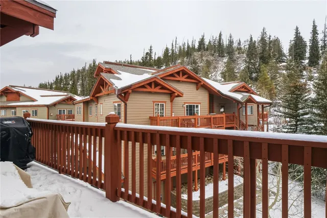 a view of a house with wooden deck and furniture