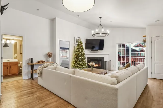 a living room with furniture a fireplace and a chandelier