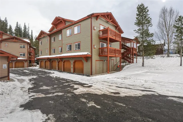 a front view of a house with a yard covered in snow