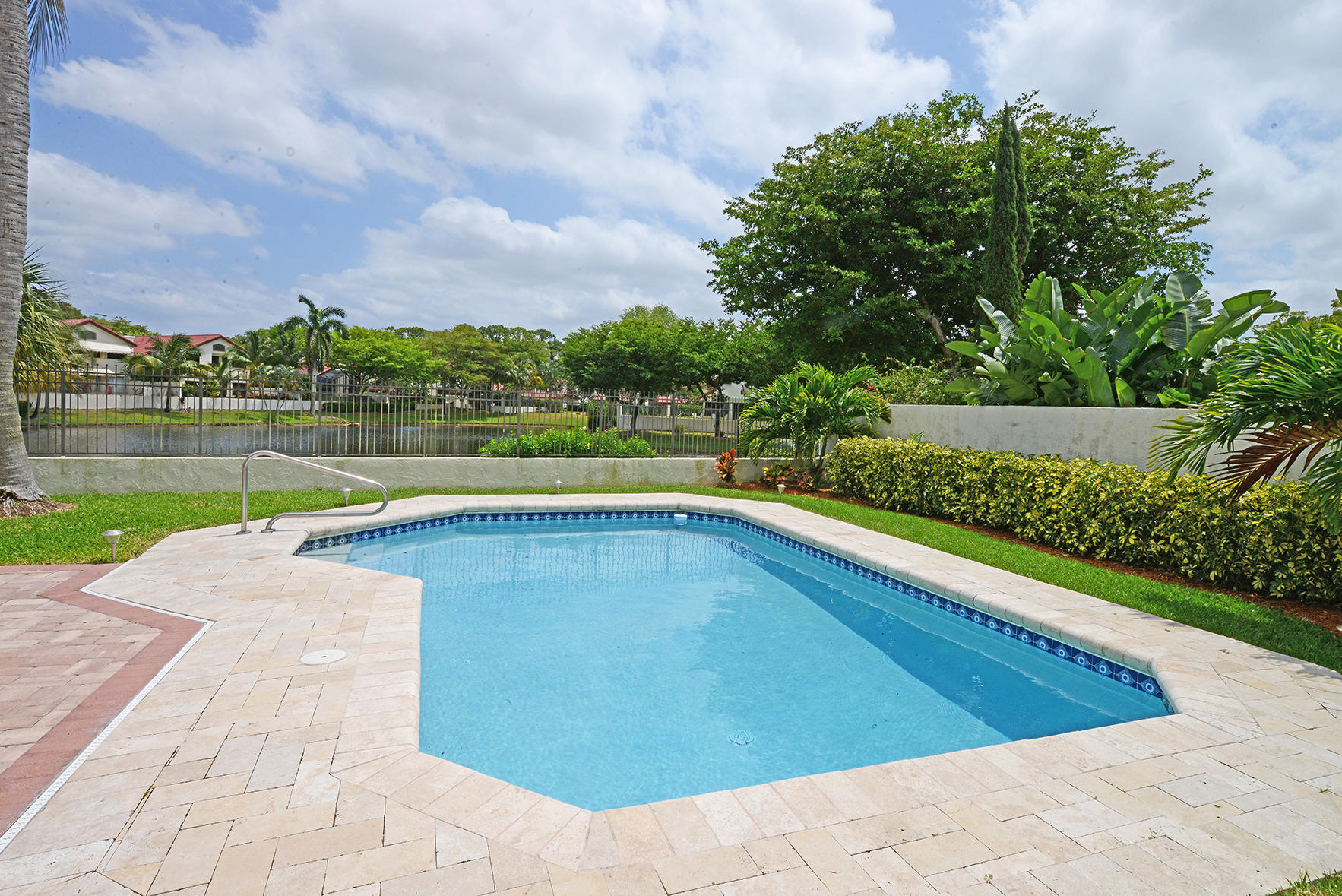 a view of swimming pool with a yard and a large tree