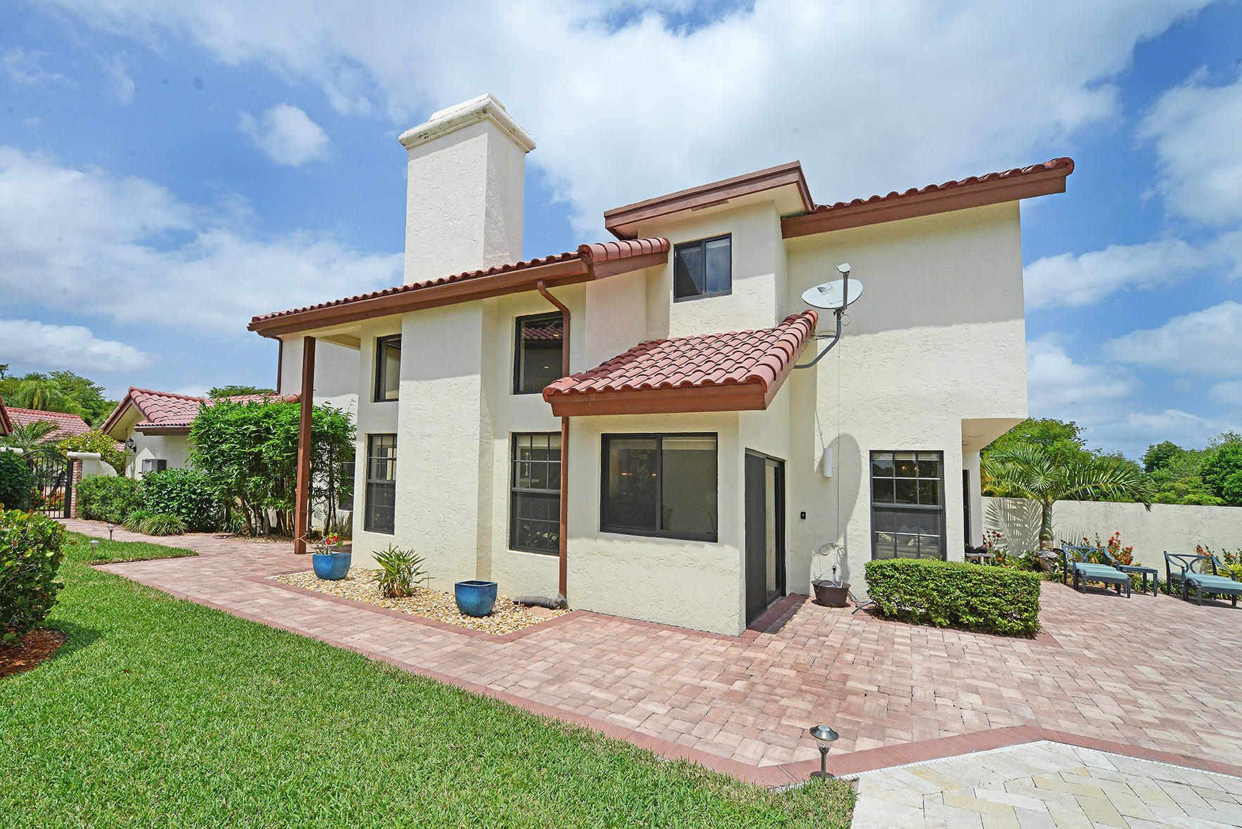 21760 Club Villa Terrace Boca Raton, FL 33433 - Photo 5 of 38 a view of a white house with a yard and plants