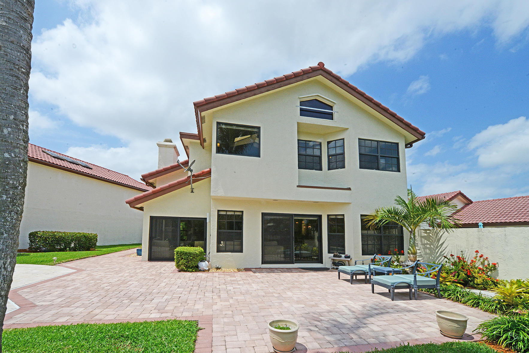 21760 Club Villa Terrace Boca Raton, FL 33433 - Photo 7 of 38 a front view of a house with a yard and potted plants